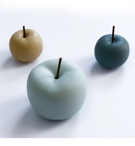 Detalle de manzanas decorativas de cerámica mate Morandi en azul claro, amarillo y verde