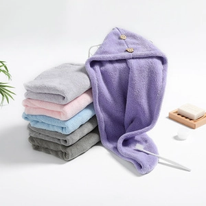 Detail of coral fleece hair drying cap with button closure in various soft pastel colors