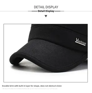 Close-up of black wool cap with silver Vashion metal logo and reinforced visor detail