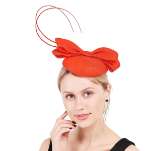 Detail of red fascinator hat featuring a large mesh bow and quill feathers on a model