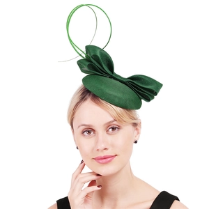 Close-up of elegant green mesh fascinator hat with oversized bow and ribbon loops