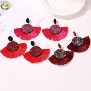 Détail des boucles d'oreilles à pompons en soie colorée avec strass en trois coloris
