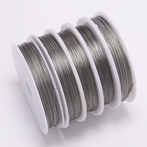 Five rolls of silver stainless steel jewelry wire on white spools for DIY crafting