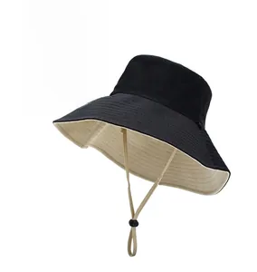 Detail of a double-sided wide brim sun hat with adjustable beige windproof rope