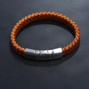 Close-up of brown braided leather men's bracelet with silver puzzle magnetic clasp