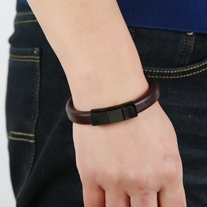 Minimalist dark brown leather bracelet with black metal clasp on a man's wrist