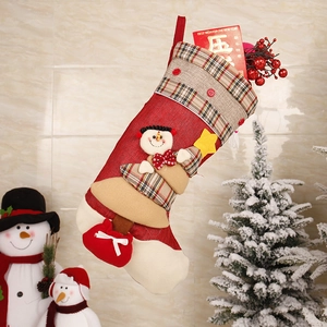 Detail of red Christmas stocking with 3D snowman applique and festive plaid cuff patterns