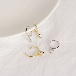Close-up of minimalist S925 silver hoop earrings with clear zircon stones in gold and silver