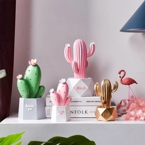 Close-up of Nordic cactus resin ornaments with geometric bases and gold accents