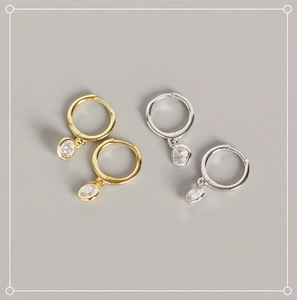 Detail of gold and silver S925 sterling silver hoop earrings with clear cubic zirconia