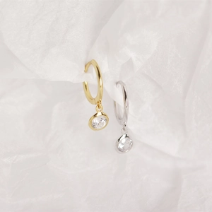 Detailed view of S925 silver hoop earrings with gold and silver bezel-set cubic zirconia