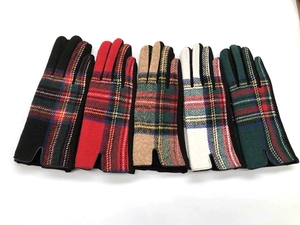 Flat lay of five wool plaid gloves in black, red, khaki, white, and green patterns