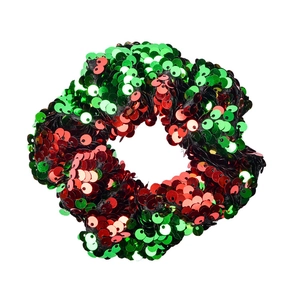 Detailed view of red and green reversible sequin scrunchie hair tie on white background