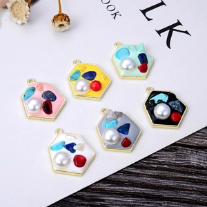 Flat lay of six hexagonal pendants with colorful drip oil, faux pearls, and crushed stones