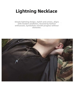 Detailed view of a silver lightning bolt pendant necklace on model in streetwear outfit