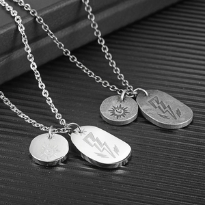 Macro shot of silver and grey steel necklaces with sun smile and lightning pendants