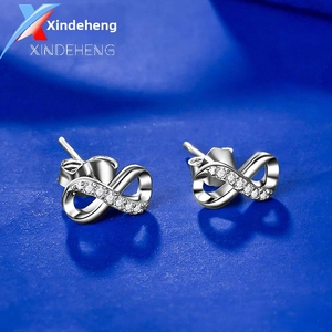 Macro detail of silver S925 infinity stud earrings with white diamond accents