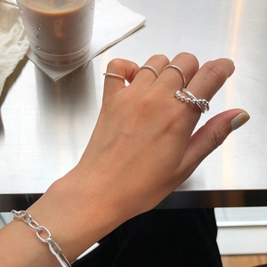 Macro shot of 925 sterling silver beaded and minimalist rings styled on a hand