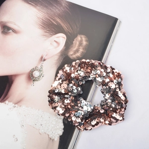 Sparkling two-tone mermaid sequin hair scrunchie in rose gold and silver on a white background