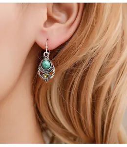 Nahaufnahme von Vintage-Silberohrringen mit Türkis-Anhänger und Hohlbohrungen