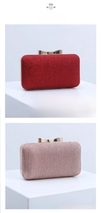 Close-up of pleated satin clutch bag with shimmering fabric and gold bow clasp