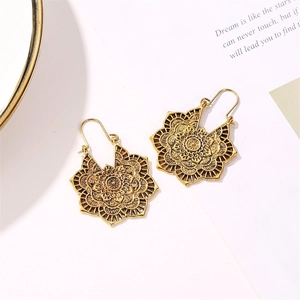 Détail de boucles d'oreilles mandala dorées vintage avec motifs de fleurs ajourés précis