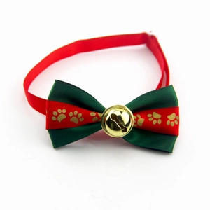 Detail of festive red and green bow tie pet collar with gold bell and paw prints