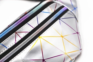 Macro detail of the iridescent geometric triangle pattern and zippers on the laser PU waist bag