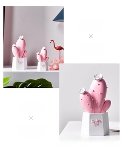 Detail of pink resin cactus decor on a white hexagonal base with Smile you text