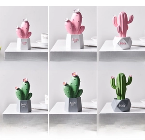 Macro detail of Nordic resin cactus ornaments with geometric base and smile typography
