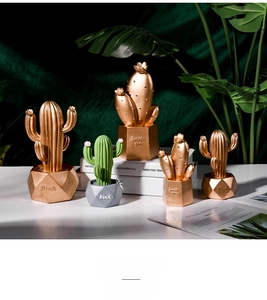 Detailed view of nordic cactus ornaments with gold finishes and geometric pots for desk decor