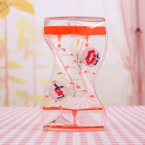 Macro detail of red liquid droplets falling past heart and kiss motifs in motion timer