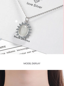 Detailed close-up of a silver sunflower necklace pendant with white opal and small crystals