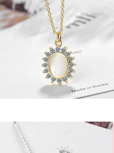 Close-up of a gold oval opal necklace with a sparkling diamond halo and Made in Korea tag