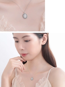 Detail shot of vintage silver flower necklace with oval white cat eye stone pendant