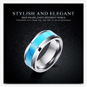 Macro shot of 8mm stainless steel ring with turquoise inlay on a textured gray surface