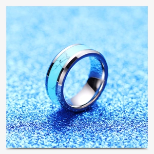Macro shot of 8mm silver stainless steel ring with turquoise marble inlay on blue glitter