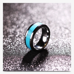 Macro shot of 8mm black stainless steel ring with natural turquoise inlay on glitter background