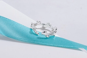 Macro detail of silver olive leaf ring featuring polished finish and adjustable open band