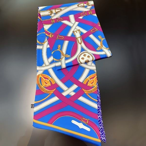 Luxury blue silk scarf with equestrian belt print shown flat on a black glossy surface