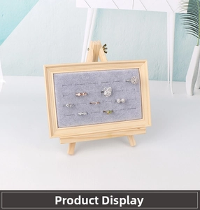 Detail of wooden jewelry display rack with gray velvet lining holding multiple rings