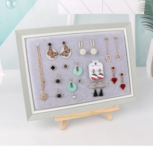 Detail of wooden jewelry frame with grey velvet lining for earrings and necklaces