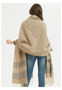 Detail of the soft cashmere feel texture and colorful striped fringes on the long shawl