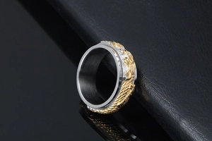 Macro detail of rotating gold dragon relief on silver stainless steel punk ring