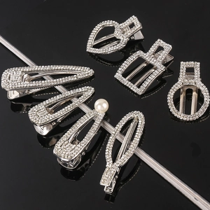Set of six shimmering silver-tone hair clips with rhinestones and pearl on dark background