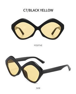 Detail view of irregular geometric sunglasses with black frame and amber yellow lenses