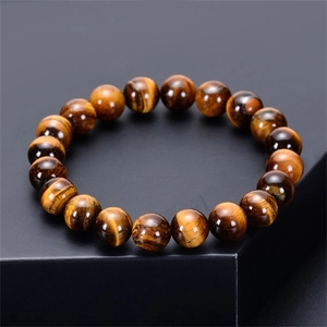 Close-up of natural tiger eye stone bracelet beads showing golden brown cat-eye effect