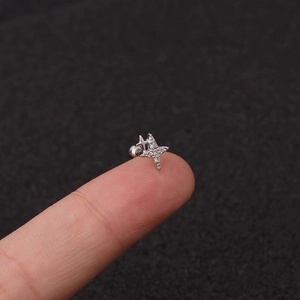 Macro view of silver star stud earring with zircons and ball screw back held by hand