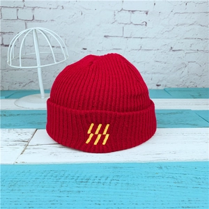 Red ribbed knit beanie for men and women featuring yellow embroidered stripe details