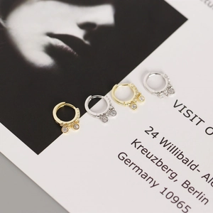 Detail of silver and gold teardrop earrings with crystals on a vintage card